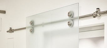 Schiebetüren aus Milchglas mit sichtbarer Stange und Gleiträdern.