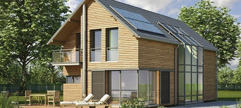 Modernes Einfamilienhaus mit Holzfassade, großen Fensterfronten, Balkon und Solarpanelen auf dem Dach.